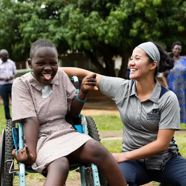 A physical therapy student with a Ugandan patient who's full of joy