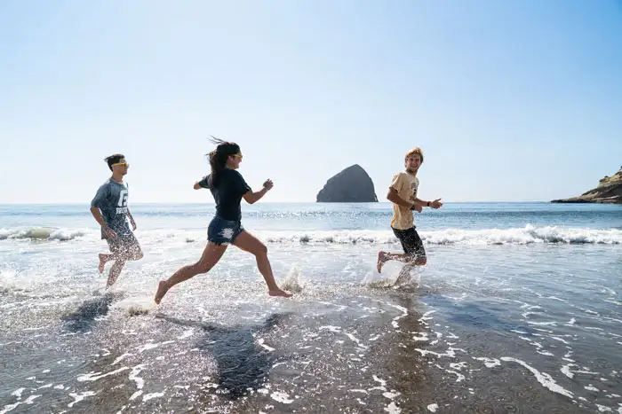 3 students frolicking along the Oregon beach