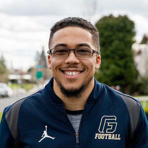 Antwon Weary wearing a George Fox jacket and looking at the camera