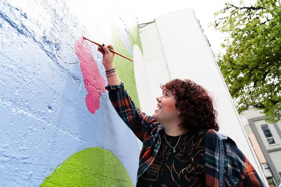 Student smiles while painting