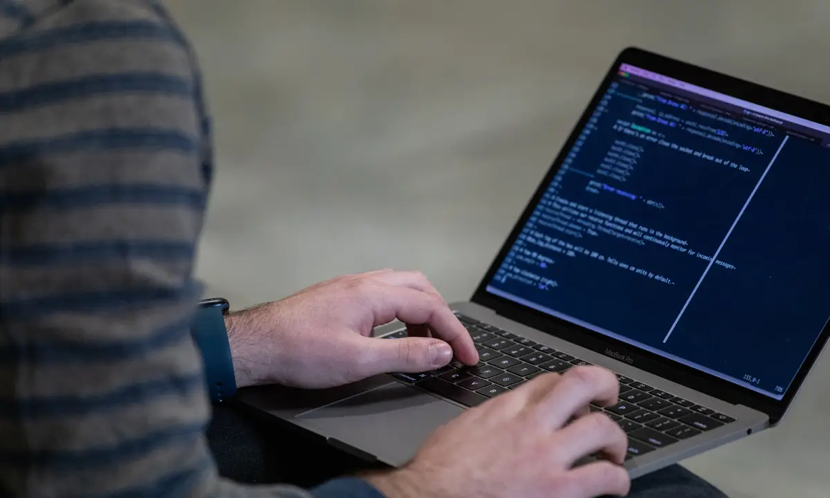 person typing code on their computer