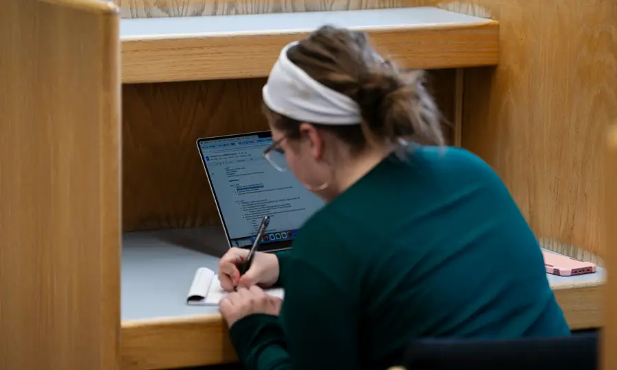 A girl working on her laptop in a work station