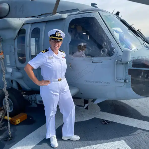 Allison standing smiling next to a helicopter
