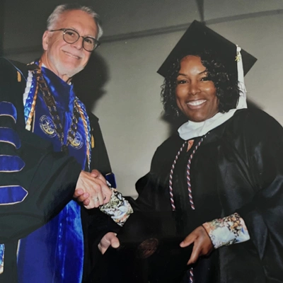 Priscilla Dorsey shaking Robin Baker's hand at the 2025 Commencement Ceremony