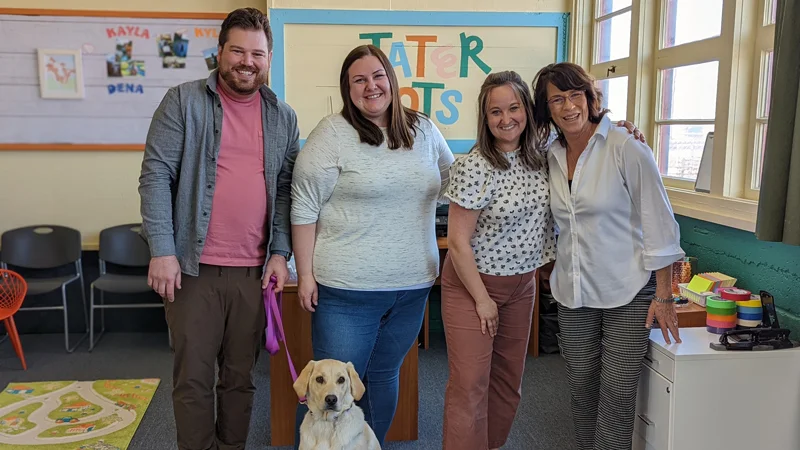 Taylor with friends and colleagues, smiling for a picture at Tater Tots Pediatric Therapy
