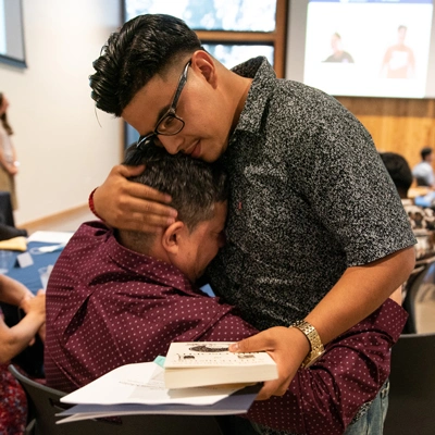Liberation Scholar giving someone a hug