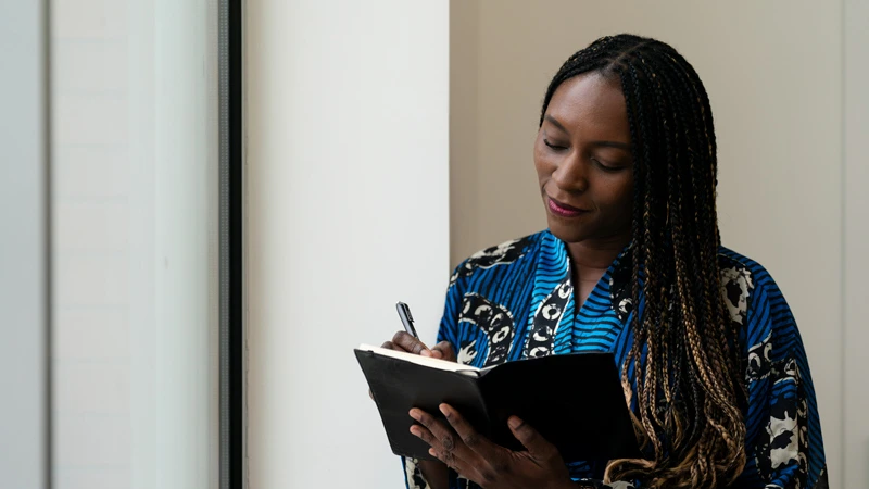 Bili Sule writing in a notebook