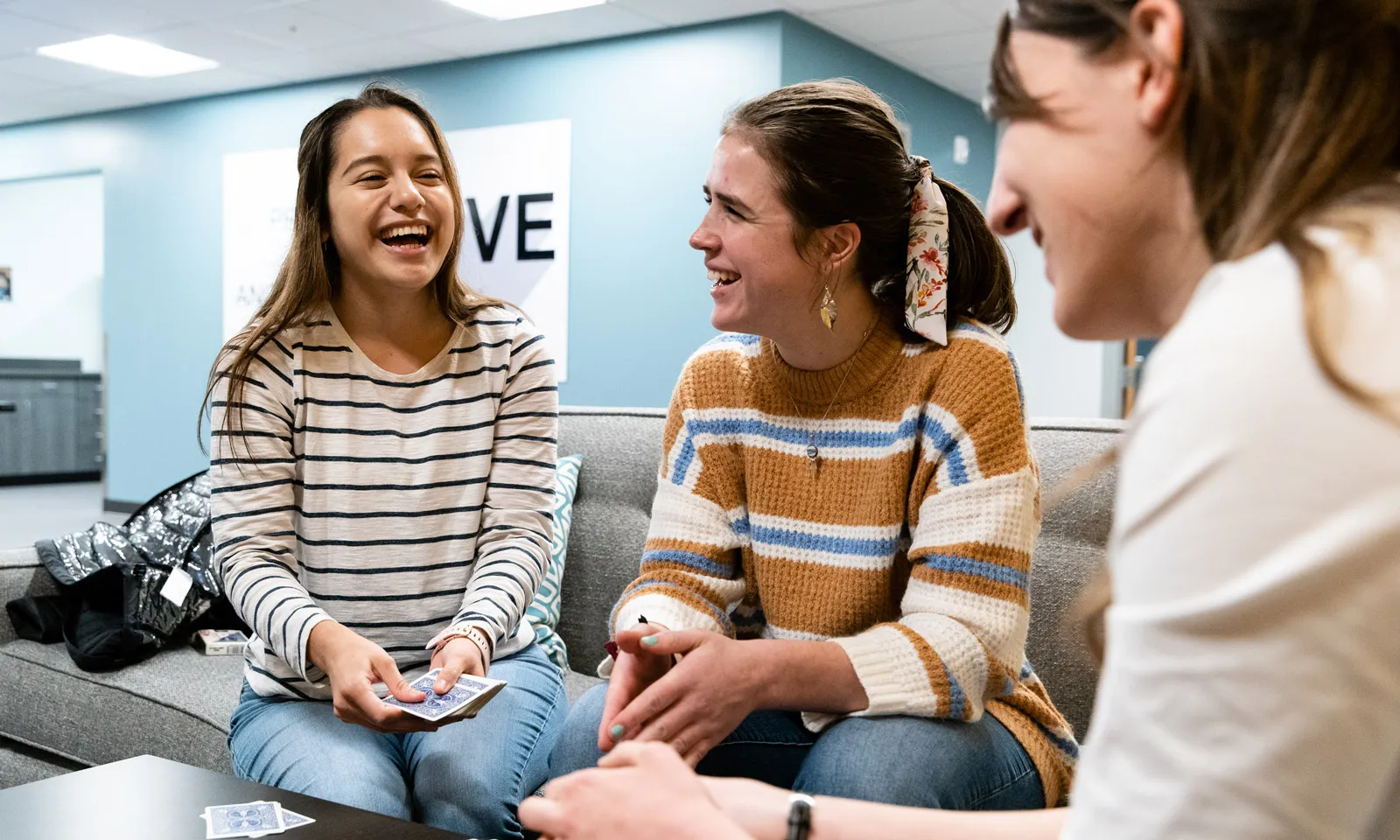students playing a card game in a dorm lobby