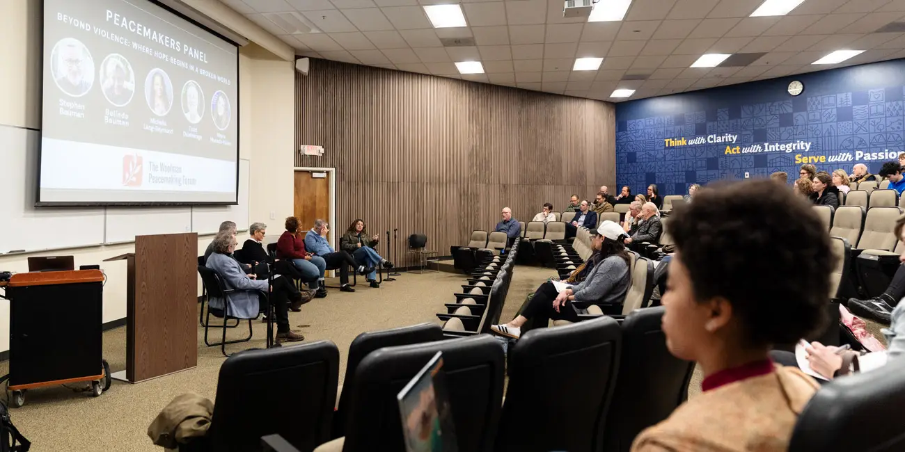 6 panelists sit in front of a crowd in the auditorium at George Fox