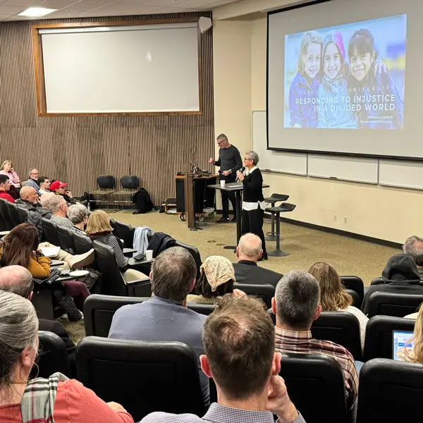 5 Panelists talk in front of a crowd at George Fox 