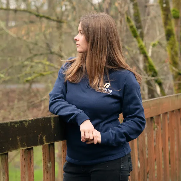 Schroeder looks off to the left on a bridge on campus