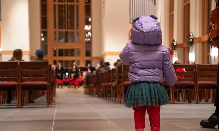 A young child in awe of Christmas in the George Fox Chapel
