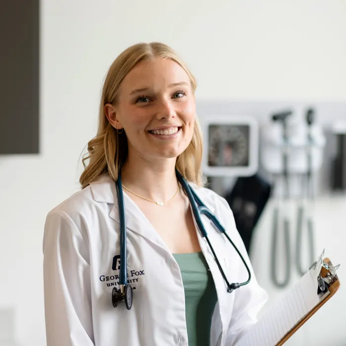 George fox pre-med student smiles for a photo in scrubs 