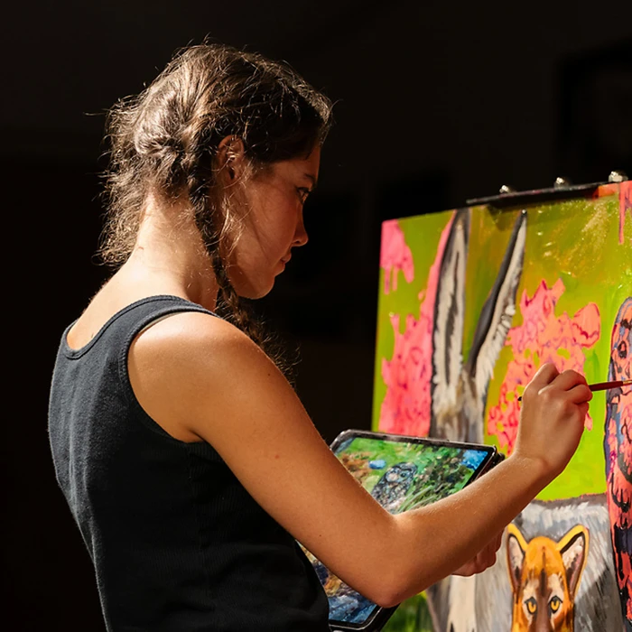 Student painting a canvas