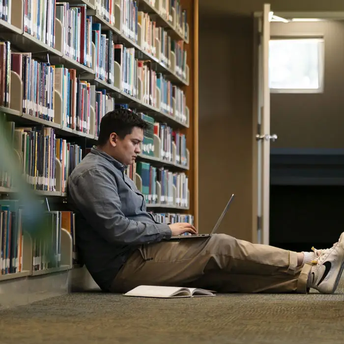 A student working on his laptop in the library