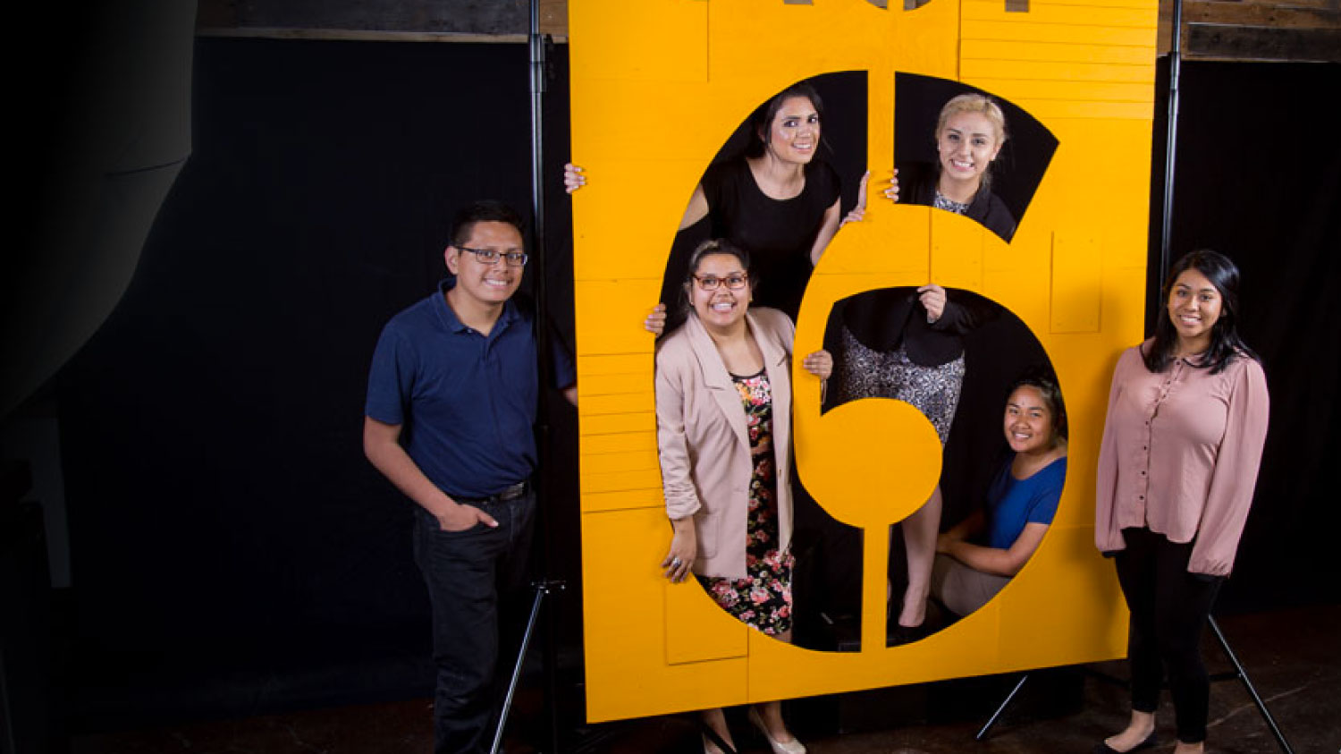 Act Six scholars posing behind a cutout of the number 6