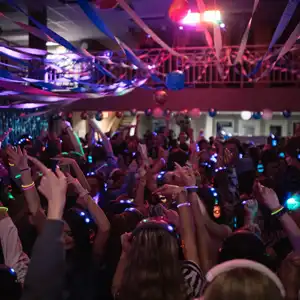 A sea of students dancing under a ceiling of streamers
