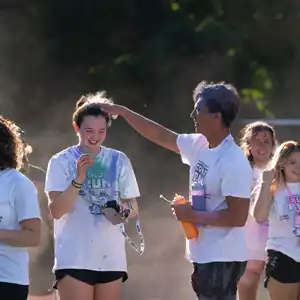 Student ruffling color out of another students hair after the color run
