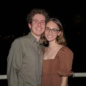 A couple posing together on a boat at night