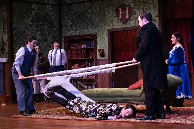 Student falling through a stretcher in The Play That Goes Wrong photocall