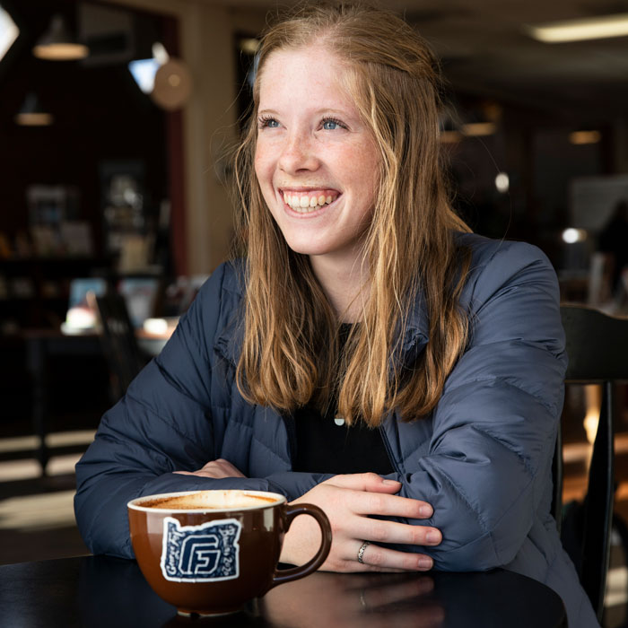 Student sitting at table with a cup of coffee