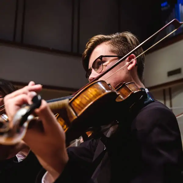 Close up shot of a student playing the violin during a concert