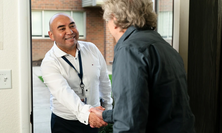 Counselor greeting a client at their door