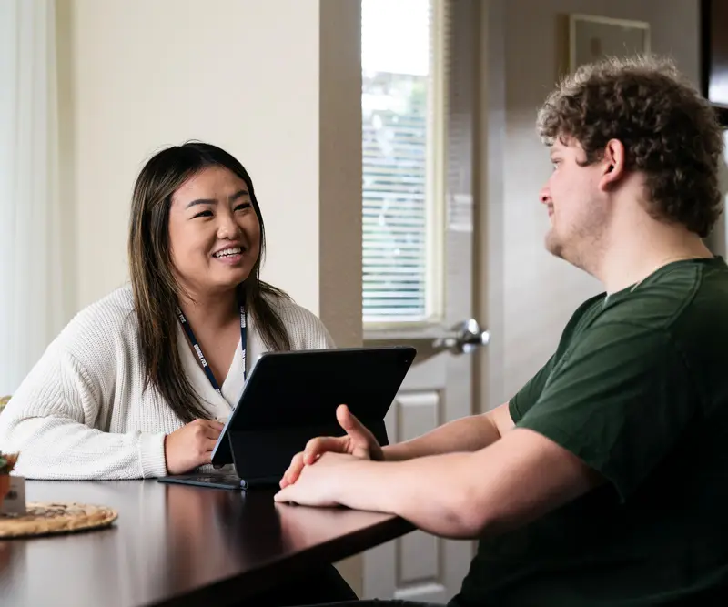 Counseling graduate smiles and laughs with a client in a casual setting