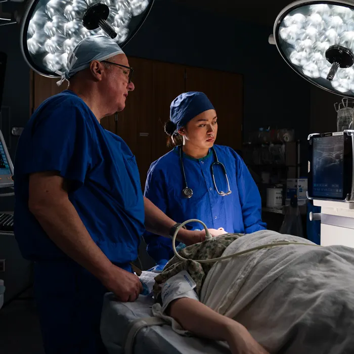 Professor shows student around the operating room