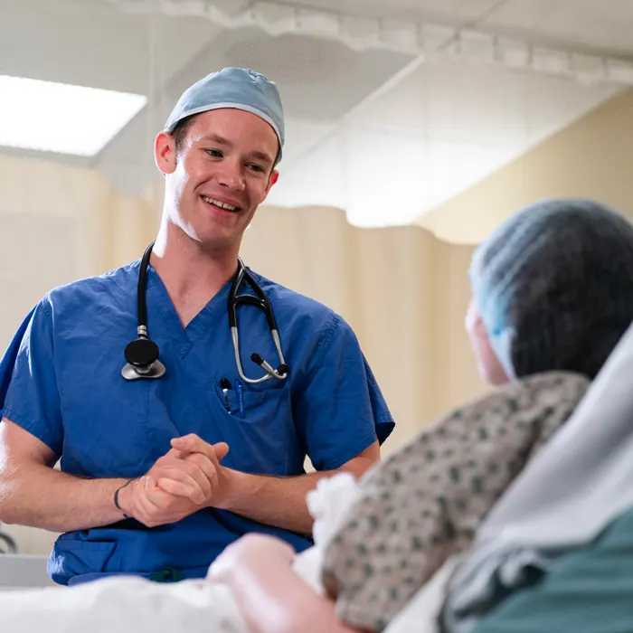 Student smiles with a patient