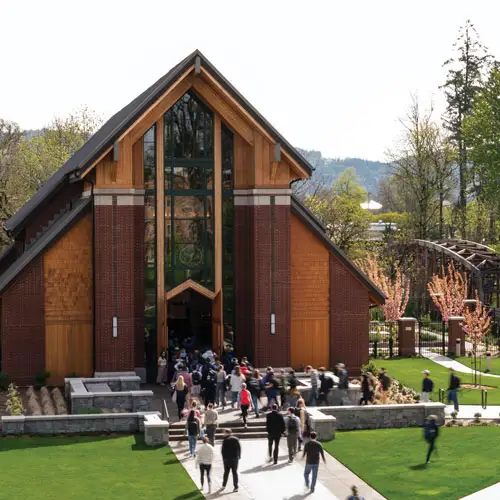 A bird's eye shot of the George Fox Chapel on an overcast day with students pouring into it