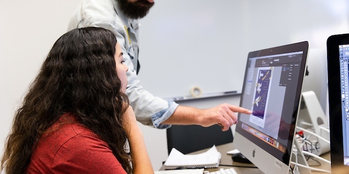 student works on computer in graphic design lab