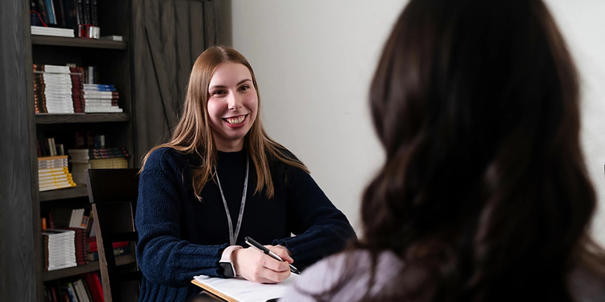 student smiling taking notes