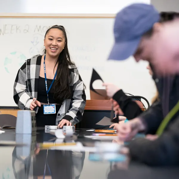 Student teacher smiles in front of a science class