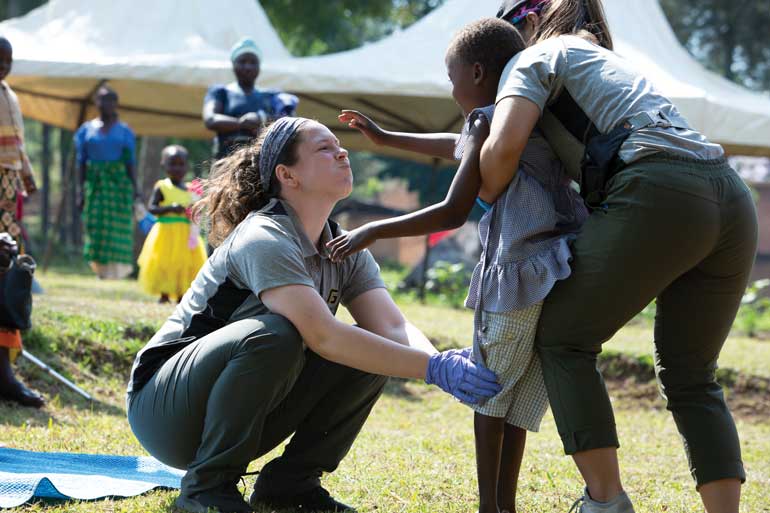 two students help a child stand