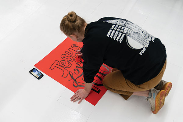 Student making signs on a piece of paper