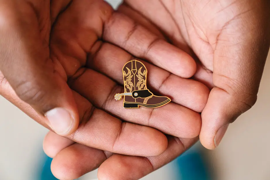 Zach Luworo holding the cowboy pin given to him for remembrance of Kyle Kincaid