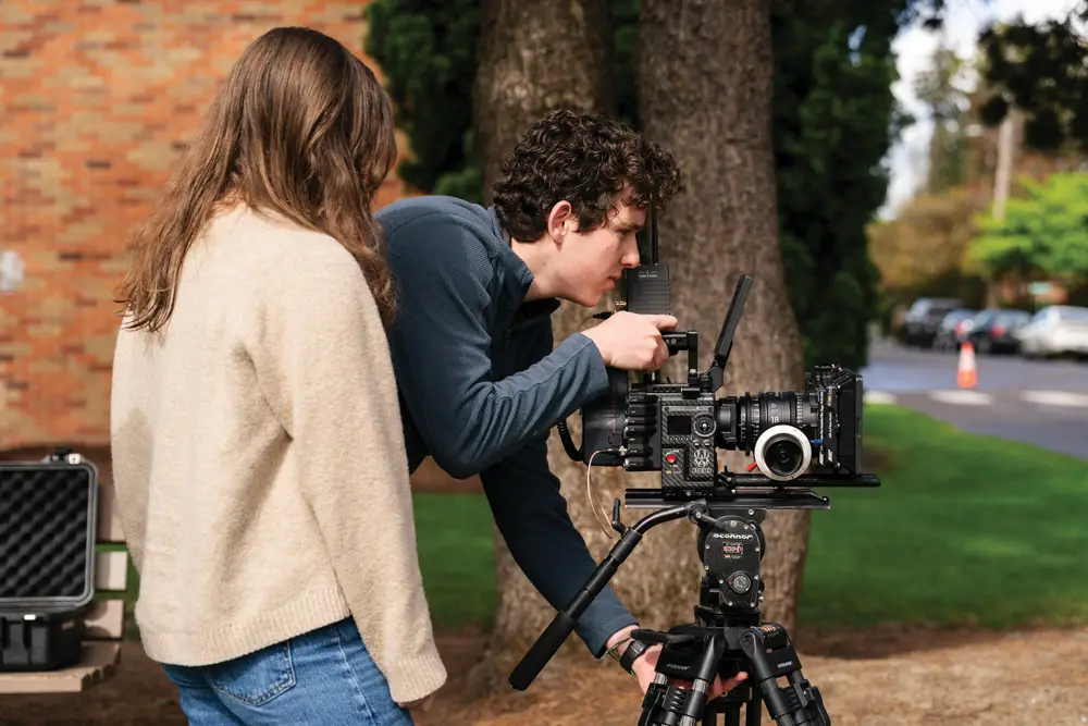 Jack holds a camera while he helps direct a student film 