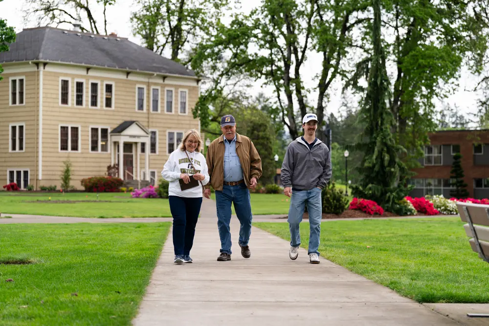 Dave and Debbie walking through the quad with scholarship recipient Daniel Chase