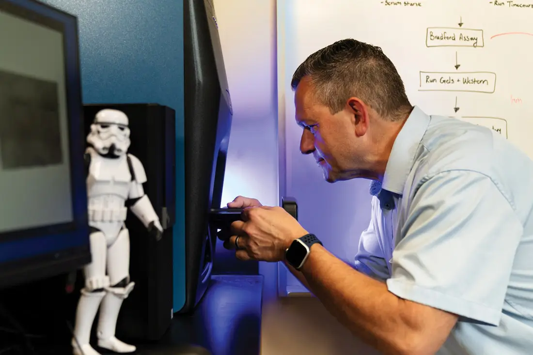 Professor John loads a sample containing proteins into a LI-COR molecular imaging system