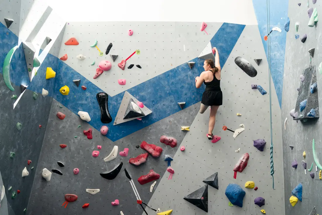 Isabelle reaching for the top of the climbing wall