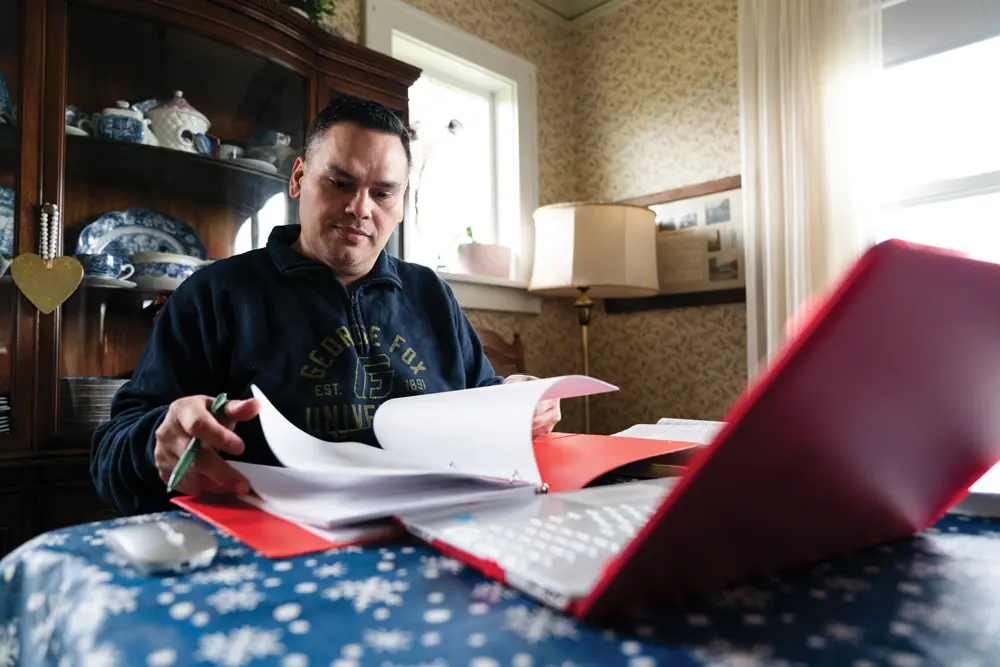 Sanchez flipping through his binder while studying at his dining room table