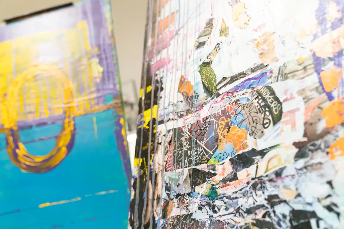 A close up of two of Marvin's pieces, the one closer being a collage of ripped up pieces of paper and graffiti style typography