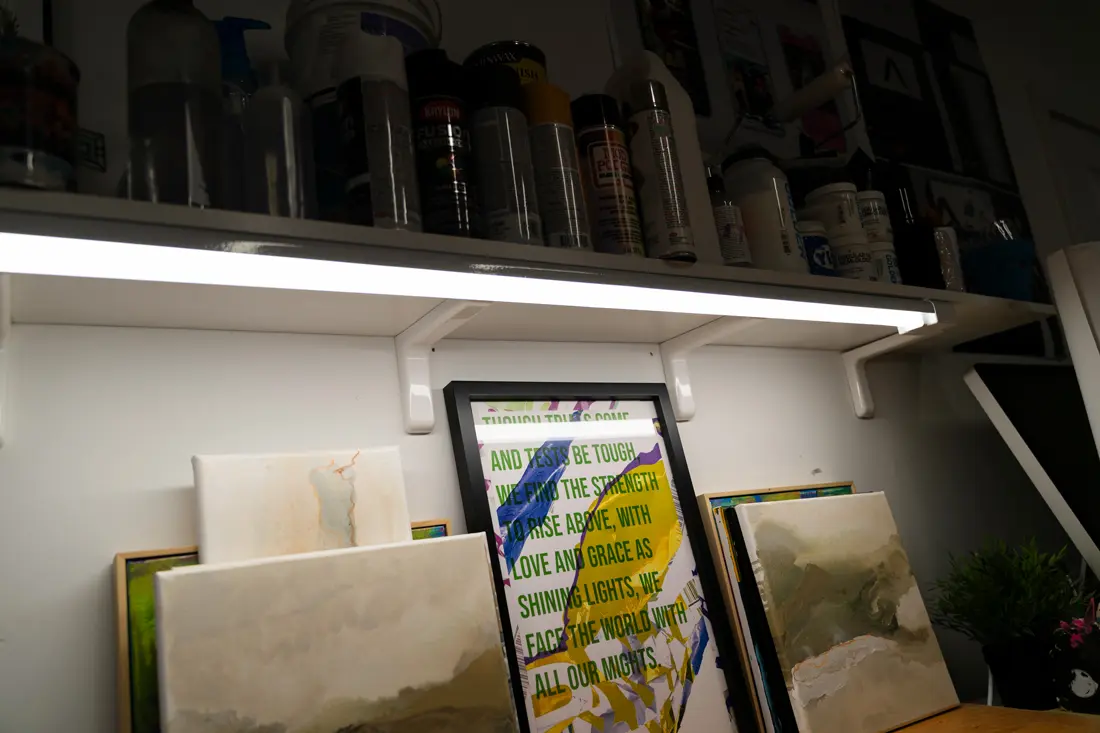 A picture of some frames and canvases under some art materials. One frame is showing a motivational quote.