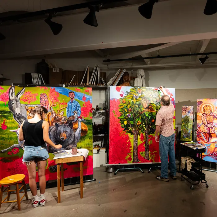 Alissa and Tim painting the mural on canvases taller than them