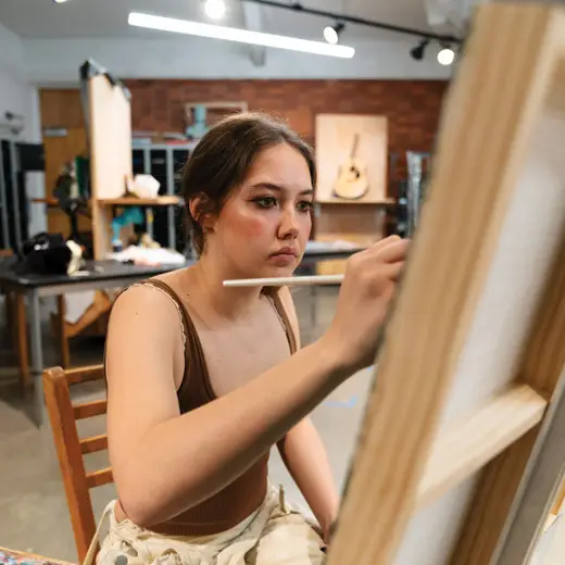 Art students Alissa works on a painting in the studio