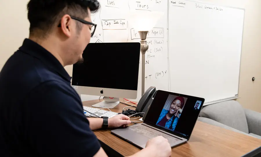 Nurse speaks with a patient remotely through zoom on a laptop