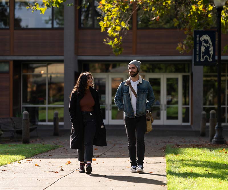 Two students walk through campus