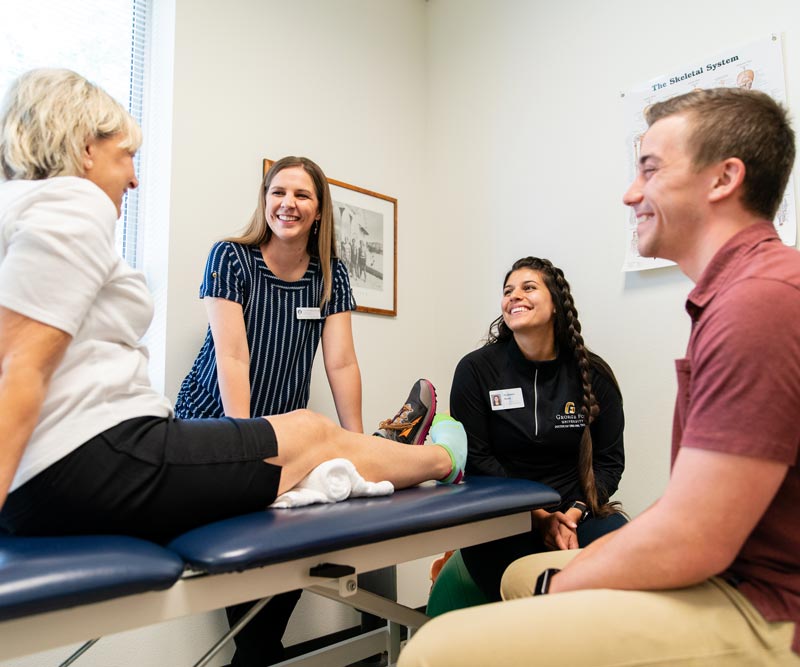 Group of students learn from professor in clinical setting