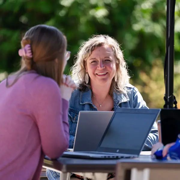 Smiling employees work outside at George Fox